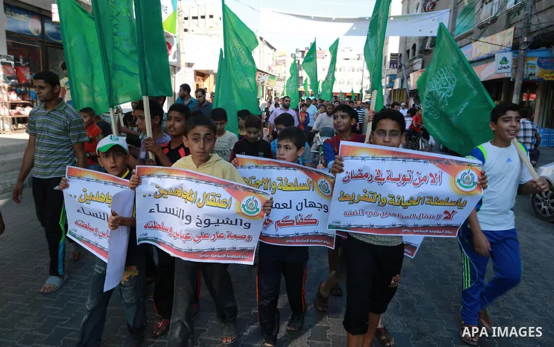 Palestinian supporters of Hamas movement hold placards during a protest against the political arrest campaign by the PA forces in the West Bank, in Jabalia refugee camp in the northern Gaza Strip, July 7, 2015. Palestini...