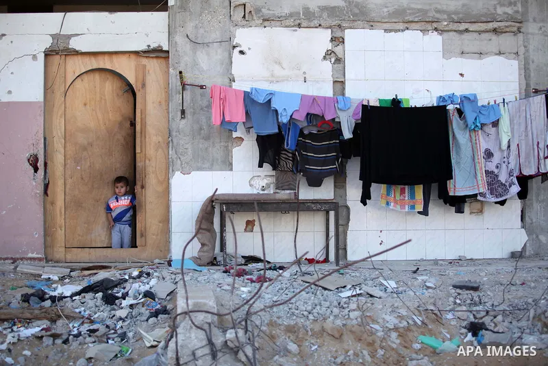 A Palestinian boy looks on in front of his family's house, that witnesses said was destroyed by Israeli shelling during a 50-day war last summer, in the east of Gaza City July 8, 2015. The majority of children living in...
