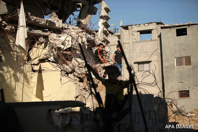 Palestinian children play on the ruins of houses, that witnesses said were destroyed by Israeli shelling during a 50-day war last summer, in the east of Gaza City July 8, 2015. The majority of children living in areas of...