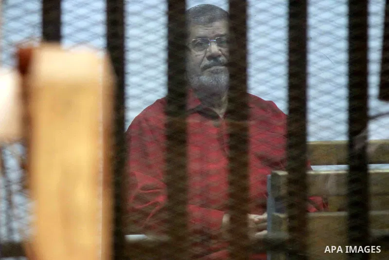 Former Egyptian president Mohammed Morsi sits behind bars during his trail in a court Cairo on July 11, 2015. Cairo Criminal Court resumes on Saturday the trial of former Islamist president Mohamed Morsi and ten others f...