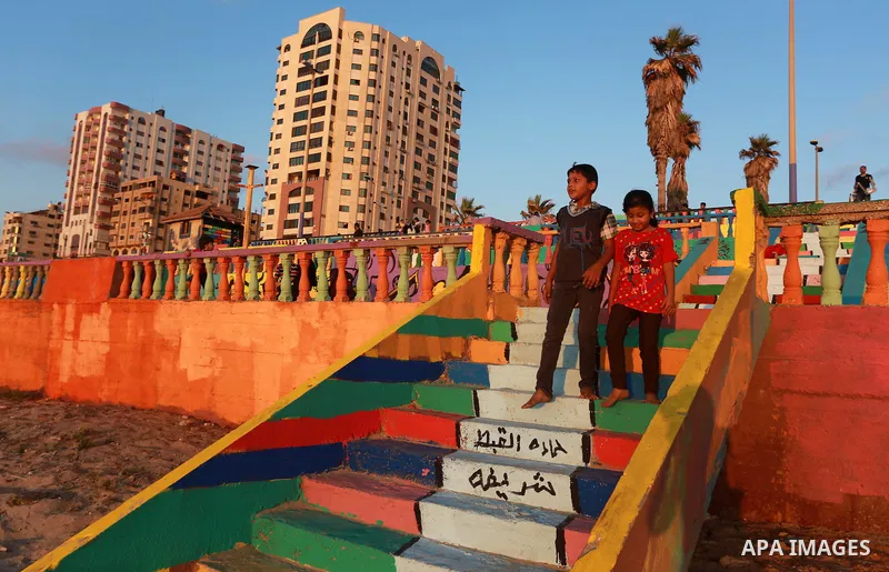 Palestinian children play on a colour stones, at the Marine Park on a beach Gaza City, on July 11, 2015. That was painted by local artists on the Gaza sea in an attempt to bring more vibrant colours to the city. Photo by...