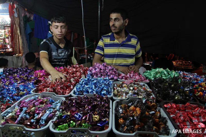 Palestinians shop in a market ahead of the Eid al-Fitr holiday marking the end of Ramadan, in Rafah in the southern Gaza Strip on July 16, 2015. Muslims the world over prepare to celebrate Eid al-Fitr, starting wth the s...