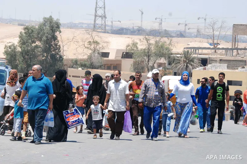 Egyptians walk in front of the Giza pyramids, on the third day of Eid al-Fitr holiday which marks the end of the Muslim holy month of Ramadan, in Cairo on July 19, 2015. Photo by Amr Sayed