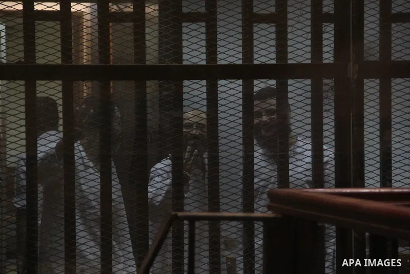 Egyptian Muslim Brotherhood defendants stand behind the bars during their trial, at the police academy on the outskirts of the capital, on July 21, 2015. Cairo criminal court resumed proceedings in the 'Qatar espionage t...