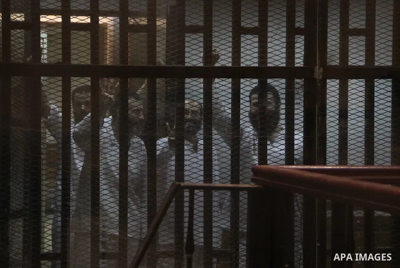 Egyptian Muslim Brotherhood defendants stand behind the bars during their trial, at the police academy on the outskirts of the capital, on July 21, 2015. Cairo criminal court resumed proceedings in the 'Qatar espionage t...