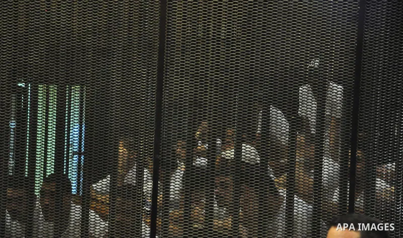 Egyptian defendants sit behind bars during their of trial stadium riot in the canal city of Port Said that left 74 people dead, in a court in the Egyptian capital, Cairo on July 25, 2015. Photo by Amr Sayed