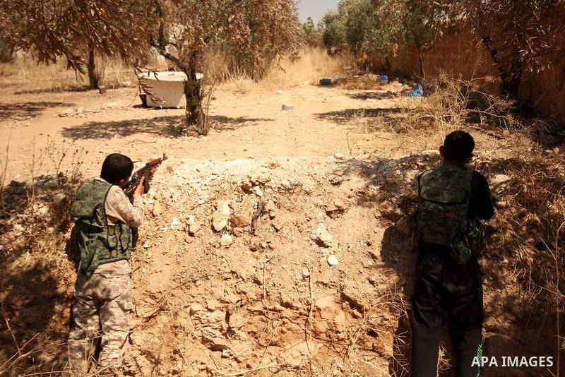 Fighters from the Free Syrian Army take position following clashes with the pro-regime forces, in Aziza village in the northern Syrian city of Aleppo, on July 28, 2015. Photo by Ameer al-Halbi