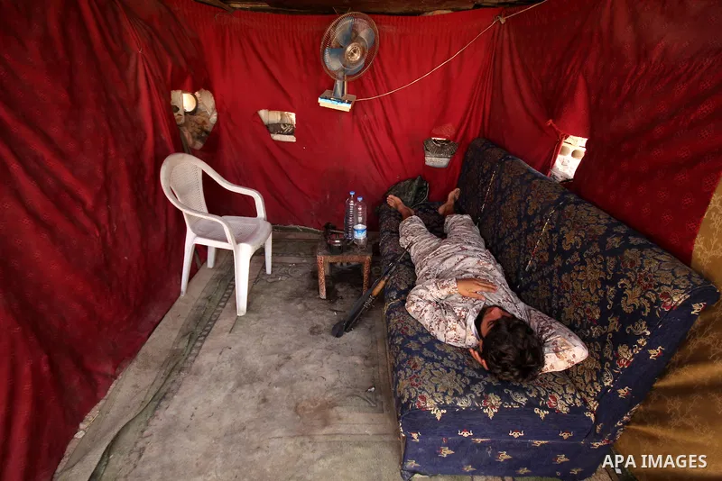 A fighter from the Free Syrian Army gets rest following clashes with the pro-regime forces, in Aziza village in the northern Syrian city of Aleppo, on July 28, 2015. Photo by Ameer al-Halbi