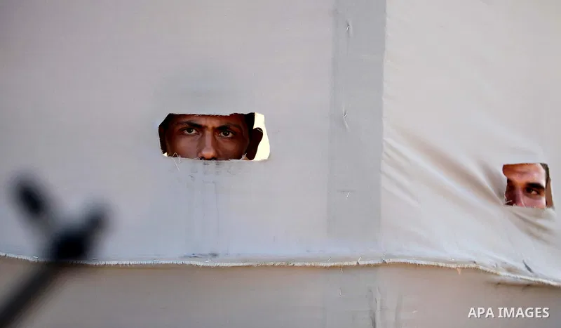 Palestinian youths look on as others attend a military-style camp organized by the Hamas movement in Gaza City on July 28, 2015. Hamas's armed wing organized "Liberation Youths Camps" for young Palestinians aged between...