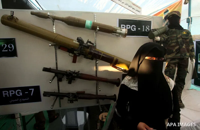 A Palestinian woman watches weapons that used during the Israeli 50-day war on Gaza Strip last summer, during a weapons exhibition in a military-style camp organized by the Hamas movement in Gaza City on July 28, 2015. H...