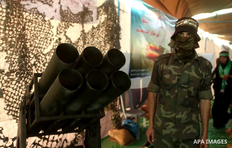 A member of Ezzeddin al-Qassam brigades stands next weapons that used during the Israeli 50-day war on Gaza Strip last summer, during a weapons exhibition in a military-style camp organized by the Hamas movement in Gaza...