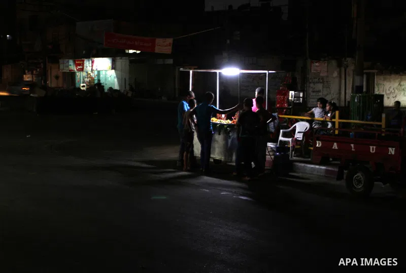 A Palestinian man prepares a falafel as he uses a candle light during a power cut in Rafah in the southern Gaza Strip, on July 28, 2015. Independent Commission for Human Rights warned Saturday of the aggravated humanitar...