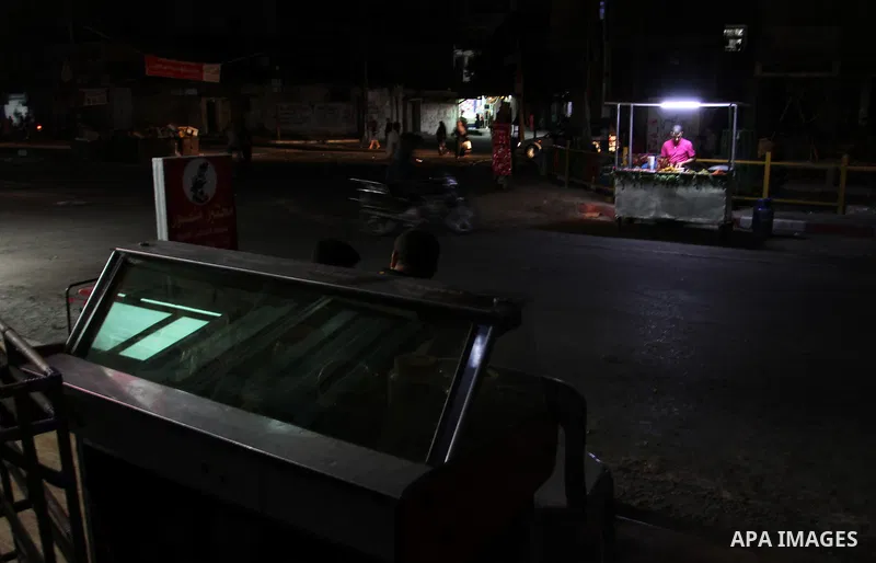 A Palestinian man prepares a falafel as he uses a candle light during a power cut in Rafah in the southern Gaza Strip, on July 28, 2015. Independent Commission for Human Rights warned Saturday of the aggravated humanitar...