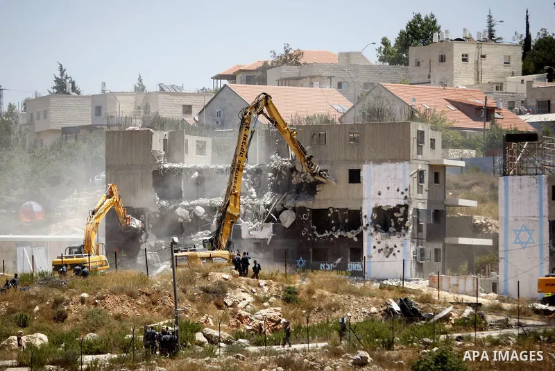 Israeli heavy machinery demolish vacant apartment blocs by order of Israel's high court, in the West Bank Jewish settlement of Beit El near Ramallah July 29, 2015. Israel gave final approval on Wednesday for plans to bui...