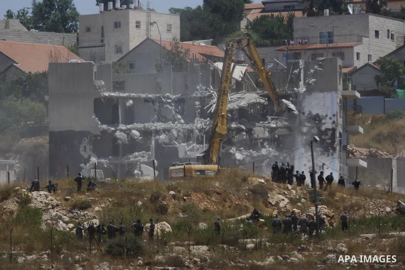 Israeli heavy machinery demolish vacant apartment blocs by order of Israel's high court, in the West Bank Jewish settlement of Beit El near Ramallah July 29, 2015. Israel gave final approval on Wednesday for plans to bui...
