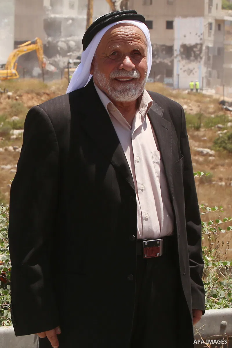 Palestinian Abdul Rahman Qasim, poses for a photograph as Israeli machinery demolish vacant apartment blocs by order of Israel's high court, in the West Bank Jewish settlement of Beit El near Ramallah July 29, 2015. Isra...