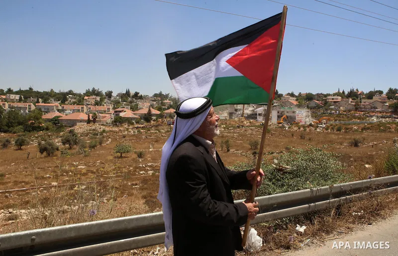 Palestinian Abdul Rahman Qasim, watches Israeli heavy machinery as they demolish vacant apartment blocs by order of Israel's high court, in the West Bank Jewish settlement of Beit El near Ramallah July 29, 2015. Israel g...