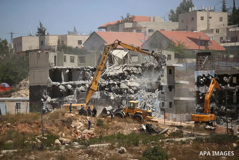 Israeli heavy machinery demolish vacant apartment blocs by order of Israel's high court, in the West Bank Jewish settlement of Beit El near Ramallah July 29, 2015. Israel gave final approval on Wednesday for plans to bui...