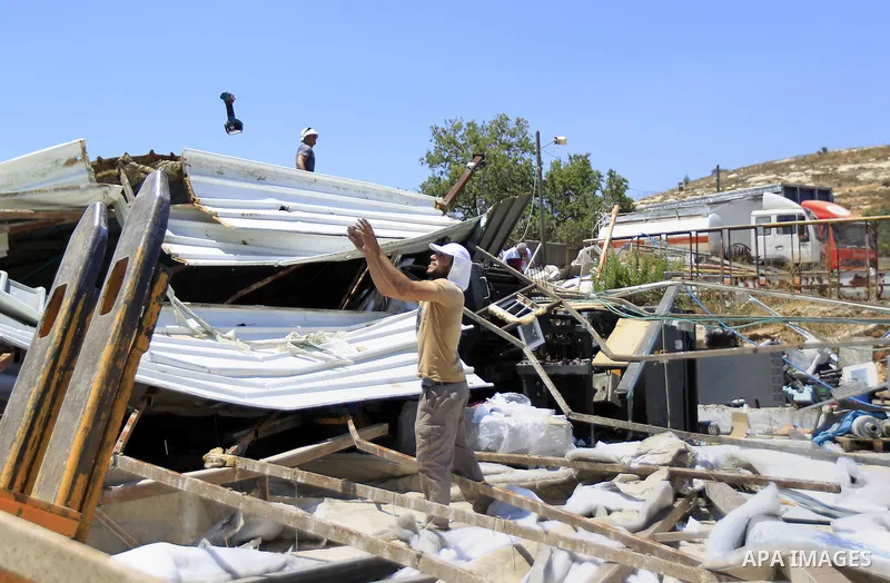 Palestinians search for their belongings after their businesses, consisting of a wedding hall and shop, were razed by the Israeli military in the Arab east Jerusalem neighbourhood of Beit Hanina on July 29, 2015. Accordi...