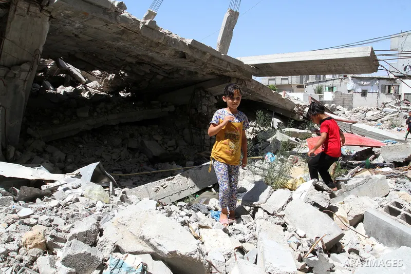 Palestinian girls play on the rubble of a house, which was destroyed during the 50-day war between Israel and Hamas militants in the summer of 2014, in Rafah in the southern Gaza Strip on July 29, 2015. An analysis of an...