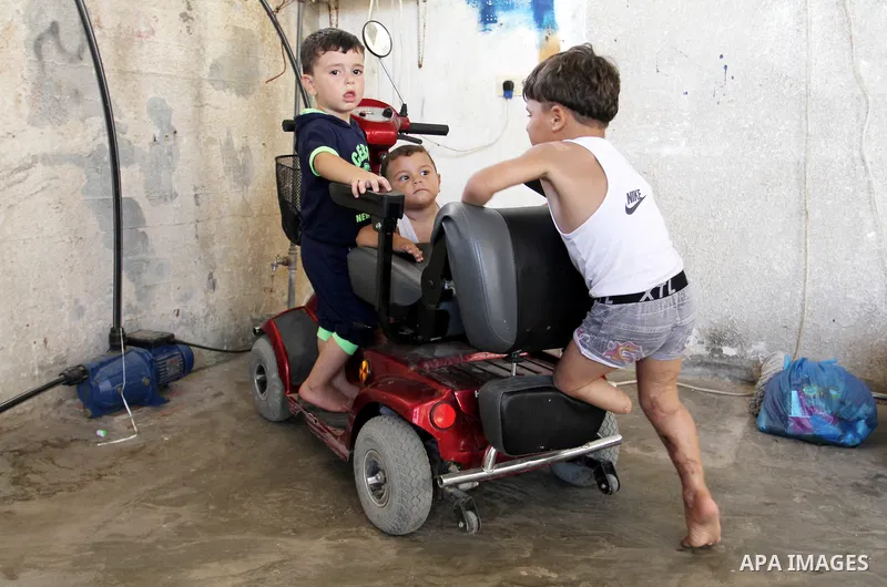 Palestinian Sharif Al-Namla, who was injured during the 50-day war between Israel and Hamas militants in the summer of 2014, plays at his family's house on July 30, 2015 in Rafah in the southern Gaza Strip. Sharif, 4, wa...