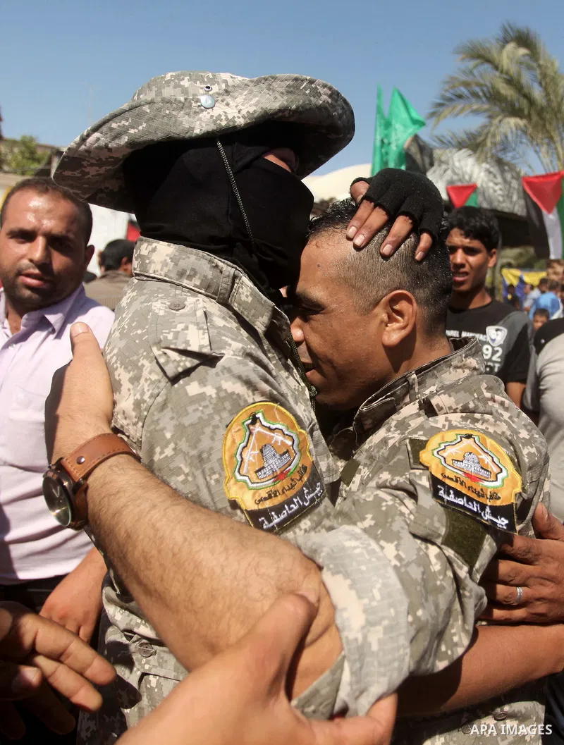 Freed Palestinian prisoner Mahmoud Abu Amra is welcomed by a member of al-Aqsa brigades, the armed wing of Fatah movement, upon his release from an Israeli jail, in Deir al-Balah in the central Gaza Strip, July 30, 2015....
