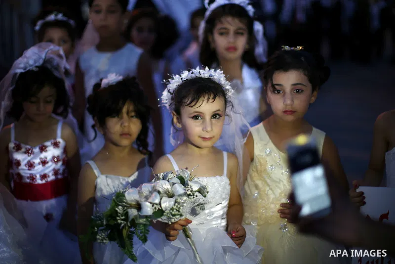 Palestinian girls attend a mass wedding ceremony in the West Bank city of Nablus, on July 30, 2015. Nearly 120 Palestinian couples were married in a ceremony supported by Palestinian President Mahmoud Abbas. Photo by Ahm...