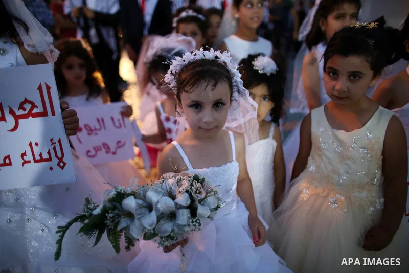 Palestinian girls attend a mass wedding ceremony in the West Bank city of Nablus, on July 30, 2015. Nearly 120 Palestinian couples were married in a ceremony supported by Palestinian President Mahmoud Abbas. Photo by Ahm...