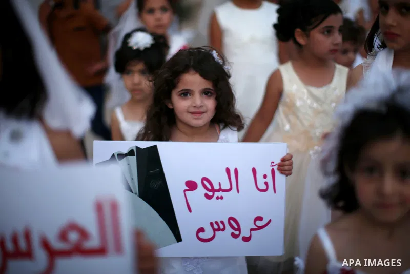 Palestinian girls attend a mass wedding ceremony in the West Bank city of Nablus, on July 30, 2015. Nearly 120 Palestinian couples were married in a ceremony supported by Palestinian President Mahmoud Abbas. Photo by Ahm...