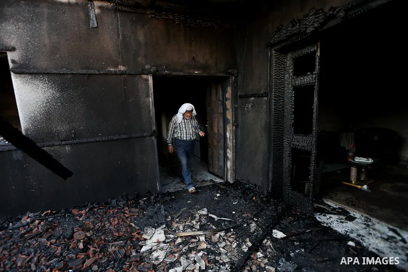 A Palestinian man inspects a house that was badly damaged from a suspected attack by Jewish extremists on two houses at Kafr Duma village near the West Bank city of Nablus July 31, 2015. The house had been empty and ther...