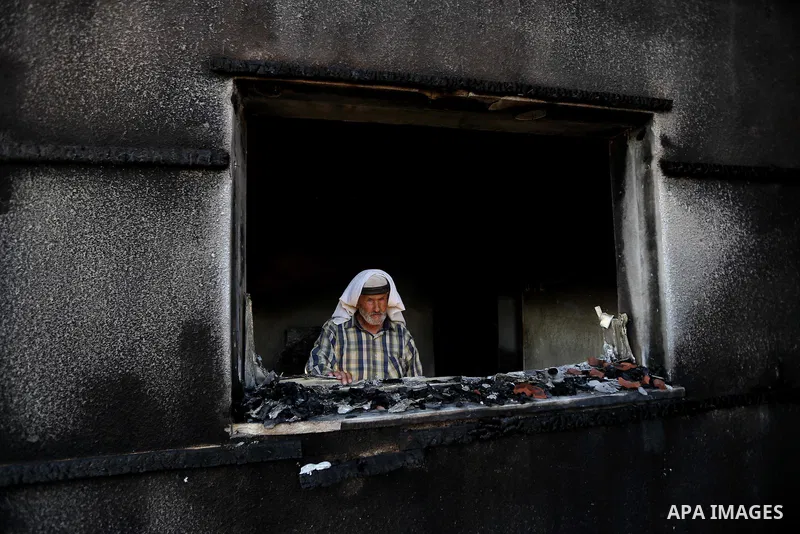 A Palestinian man inspects a house that was badly damaged from a suspected attack by Jewish extremists on two houses at Kafr Duma village near the West Bank city of Nablus July 31, 2015. The house had been empty and ther...