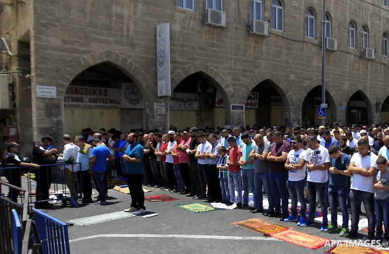 Israeli security forces stand guard as Muslim Palestinians take part in Friday noon prayers in the east Jerusalem neighbourhood of Ras al-Amud on July 31, 2015, following restrictions by Israeli police to allow entry to...