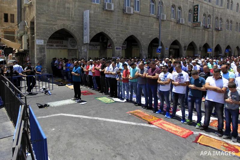 Israeli security forces stand guard as Muslim Palestinians take part in Friday noon prayers in the east Jerusalem neighbourhood of Ras al-Amud on July 31, 2015, following restrictions by Israeli police to allow entry to...