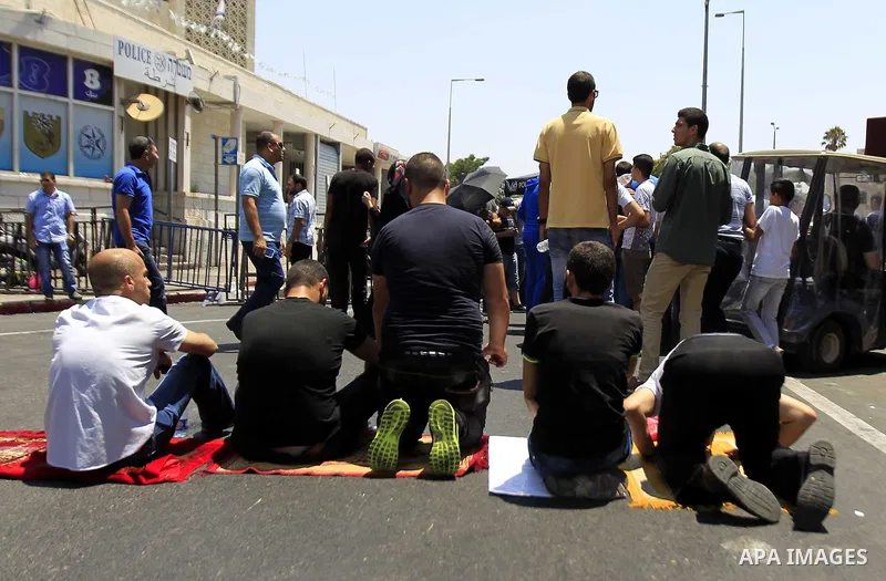 Muslim Palestinians take part in Friday noon prayers in the east Jerusalem neighbourhood of Ras al-Amud on July 31, 2015, following restrictions by Israeli police to allow entry to men only above 50-year-old wanting to a...