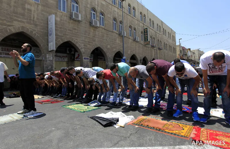 Muslim Palestinians take part in Friday noon prayers in the east Jerusalem neighbourhood of Ras al-Amud on July 31, 2015, following restrictions by Israeli police to allow entry to men only above 50-year-old wanting to a...