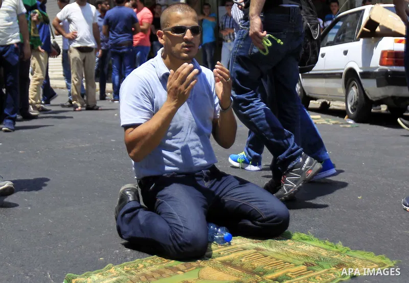 A Muslim Palestinian man takes part in Friday noon prayers in the east Jerusalem neighbourhood of Ras al-Amud on July 31, 2015, following restrictions by Israeli police to allow entry to men only above 50-year-old wantin...