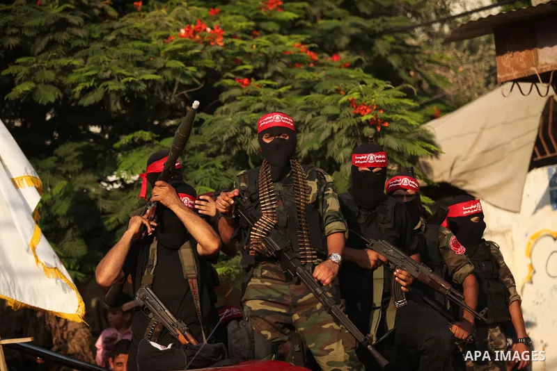 Masked Palestinian militants of the National Resistance Brigades, a group linked to the Democratic Front for the Liberation of Palestine hold their weapons during a military parade against the killing of a 18-month-old P...