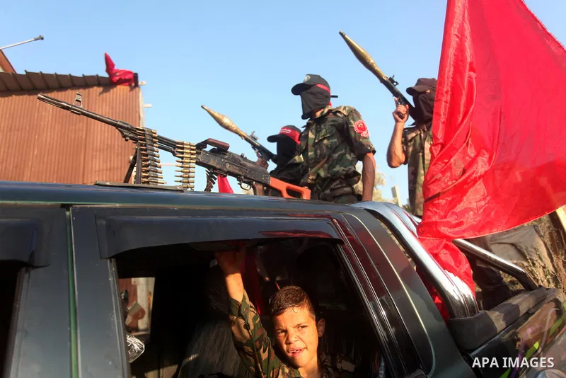 Masked Palestinian militants of the National Resistance Brigades, a group linked to the Democratic Front for the Liberation of Palestine hold their weapons during a military parade against the killing of a 18-month-old P...
