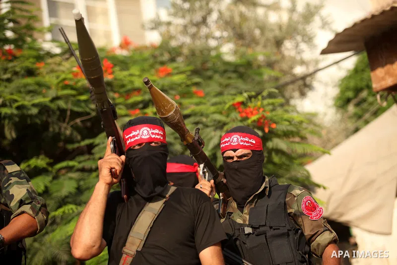 Masked Palestinian militants of the National Resistance Brigades, a group linked to the Democratic Front for the Liberation of Palestine hold their weapons during a military parade against the killing of a 18-month-old P...
