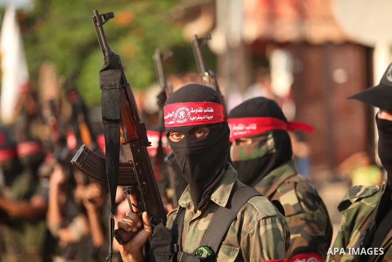 Masked Palestinian militants of the National Resistance Brigades, a group linked to the Democratic Front for the Liberation of Palestine hold their weapons during a military parade against the killing of a 18-month-old P...