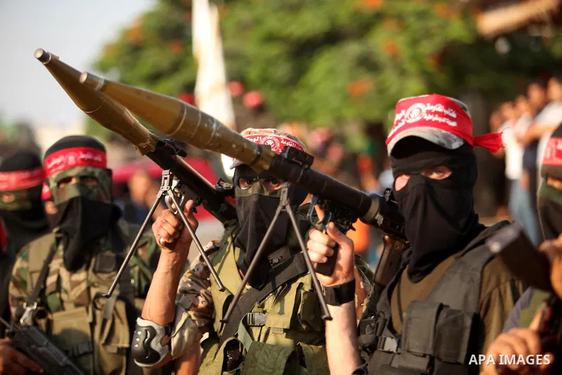 Masked Palestinian militants of the National Resistance Brigades, a group linked to the Democratic Front for the Liberation of Palestine hold their weapons during a military parade against the killing of a 18-month-old P...