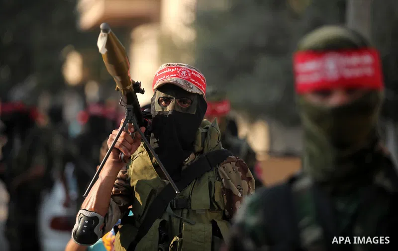 Masked Palestinian militants of the National Resistance Brigades, a group linked to the Democratic Front for the Liberation of Palestine hold their weapons during a military parade against the killing of a 18-month-old P...