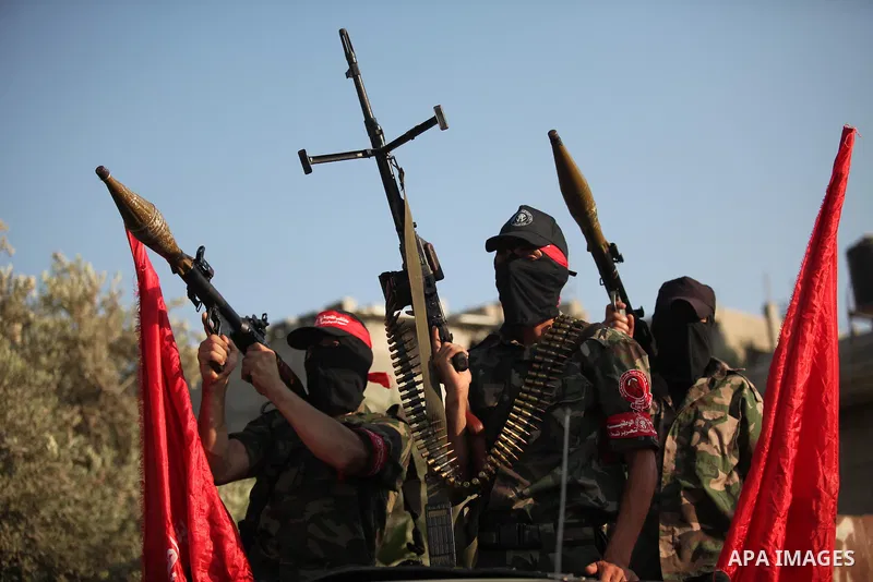 Masked Palestinian militants of the National Resistance Brigades, a group linked to the Democratic Front for the Liberation of Palestine hold their weapons during a military parade against the killing of a 18-month-old P...