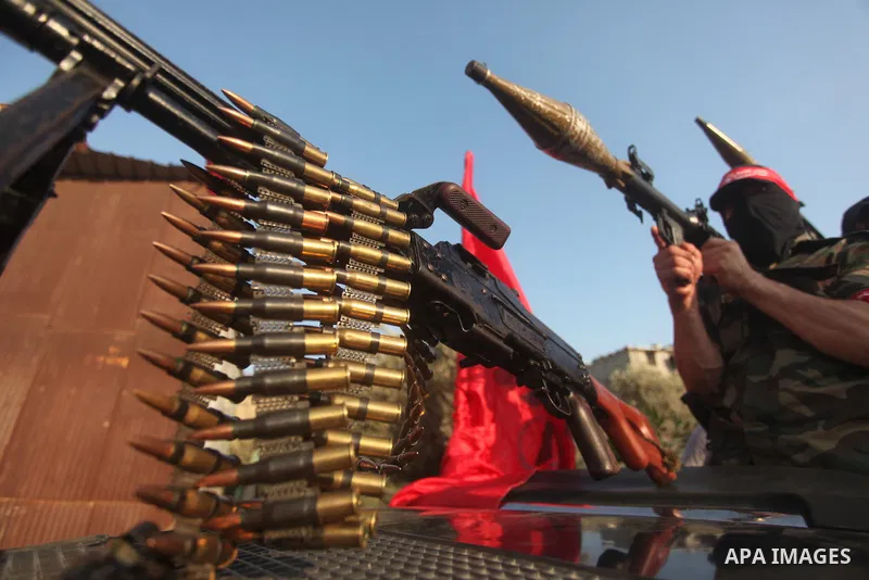 Masked Palestinian militants of the National Resistance Brigades, a group linked to the Democratic Front for the Liberation of Palestine hold their weapons during a military parade against the killing of a 18-month-old P...