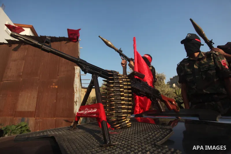 Masked Palestinian militants of the National Resistance Brigades, a group linked to the Democratic Front for the Liberation of Palestine hold their weapons during a military parade against the killing of a 18-month-old P...