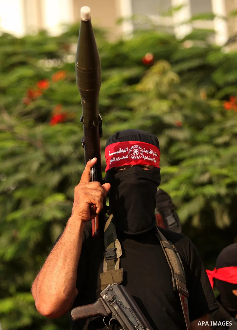 A masked Palestinian militant of the National Resistance Brigades, a group linked to the Democratic Front for the Liberation of Palestine holds his weapon during a military parade against the killing of a 18-month-old Pa...