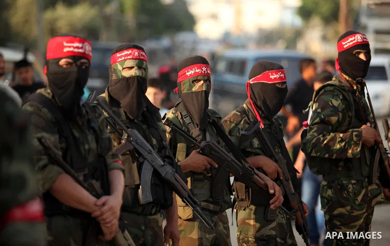 Masked Palestinian militants of the National Resistance Brigades, a group linked to the Democratic Front for the Liberation of Palestine hold their weapons during a military parade against the killing of a 18-month-old P...