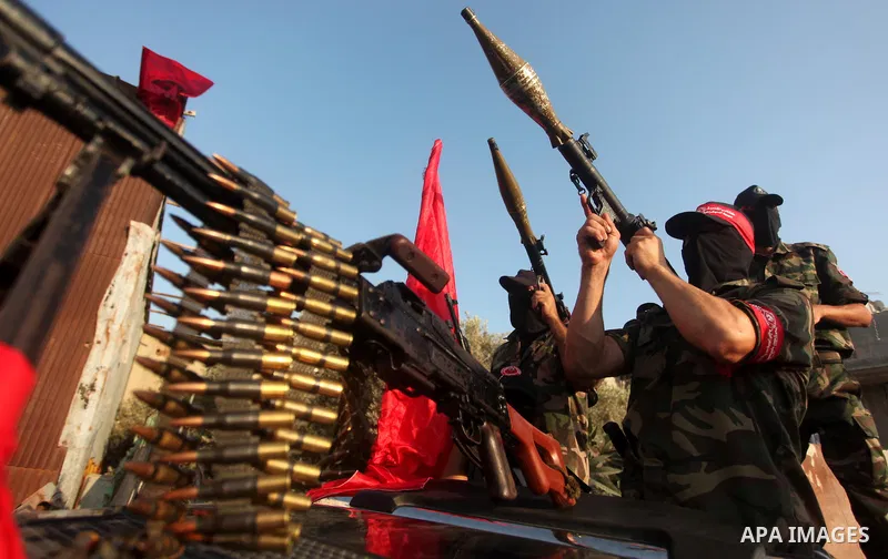 Masked Palestinian militants of the National Resistance Brigades, a group linked to the Democratic Front for the Liberation of Palestine hold their weapons during a military parade against the killing of a 18-month-old P...