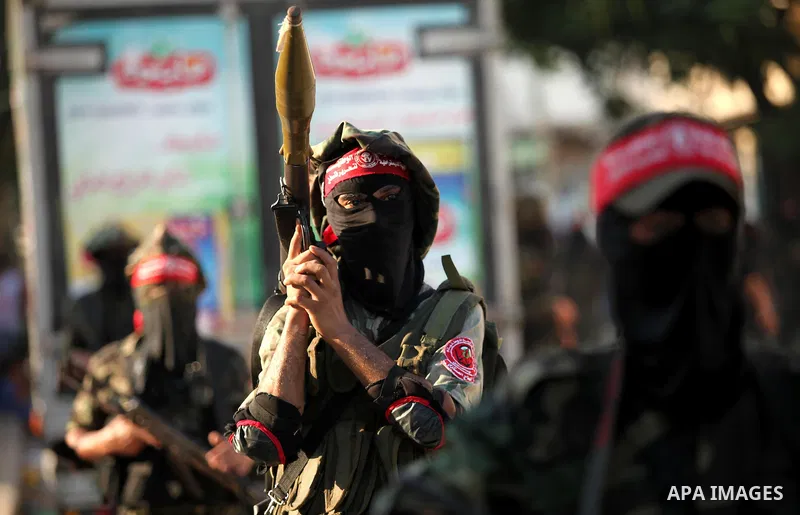 Masked Palestinian militants of the National Resistance Brigades, a group linked to the Democratic Front for the Liberation of Palestine hold their weapons during a military parade against the killing of a 18-month-old P...