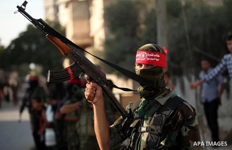 Masked Palestinian militants of the National Resistance Brigades, a group linked to the Democratic Front for the Liberation of Palestine hold their weapons during a military parade against the killing of a 18-month-old P...